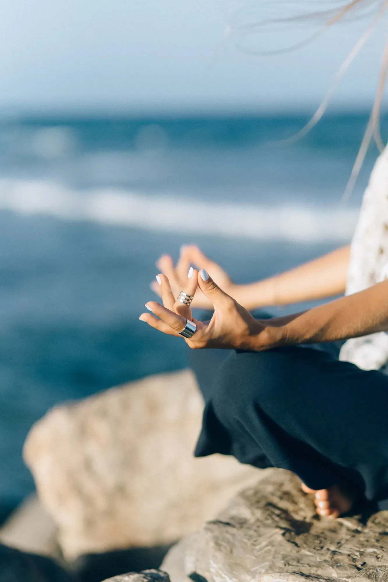 Personne en méditation face à la nature, mains en geste d'ouverture